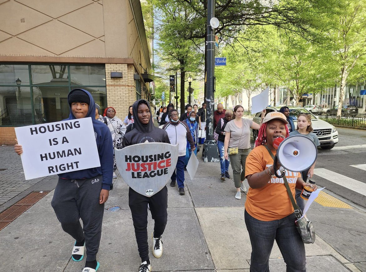 People march in street with housing justice signs