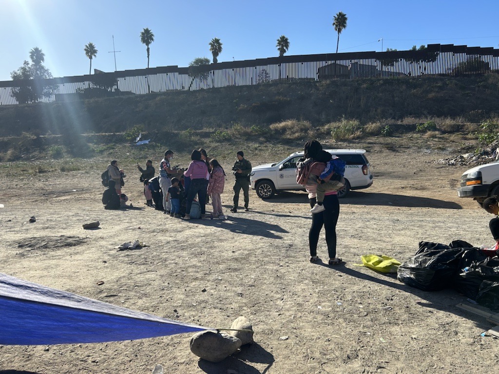 Border Patrol watches migrants between the border walls