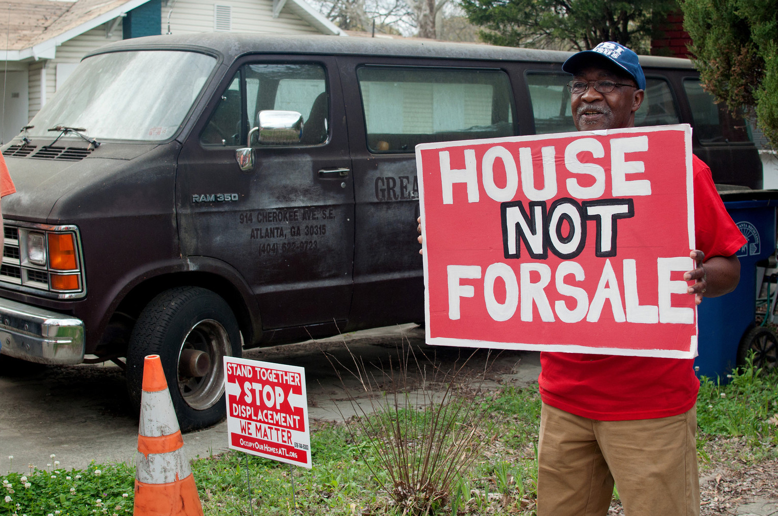 man holding sign that says house not for sale