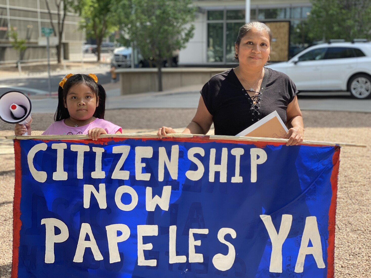 two people holding up sign that reads citizenship now