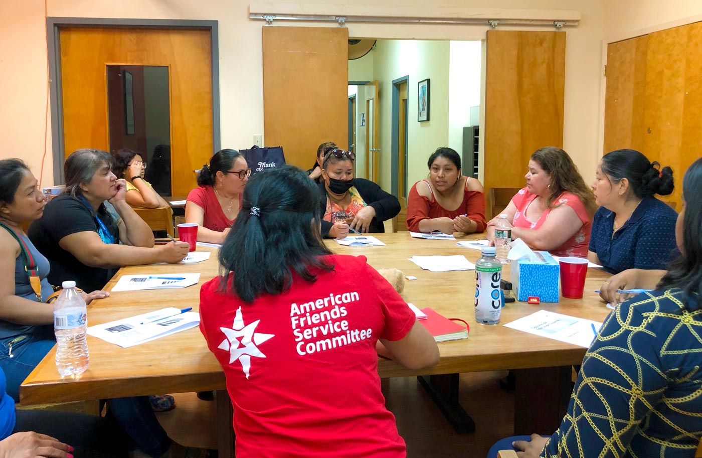 A women's group discusses immigration issues around a table