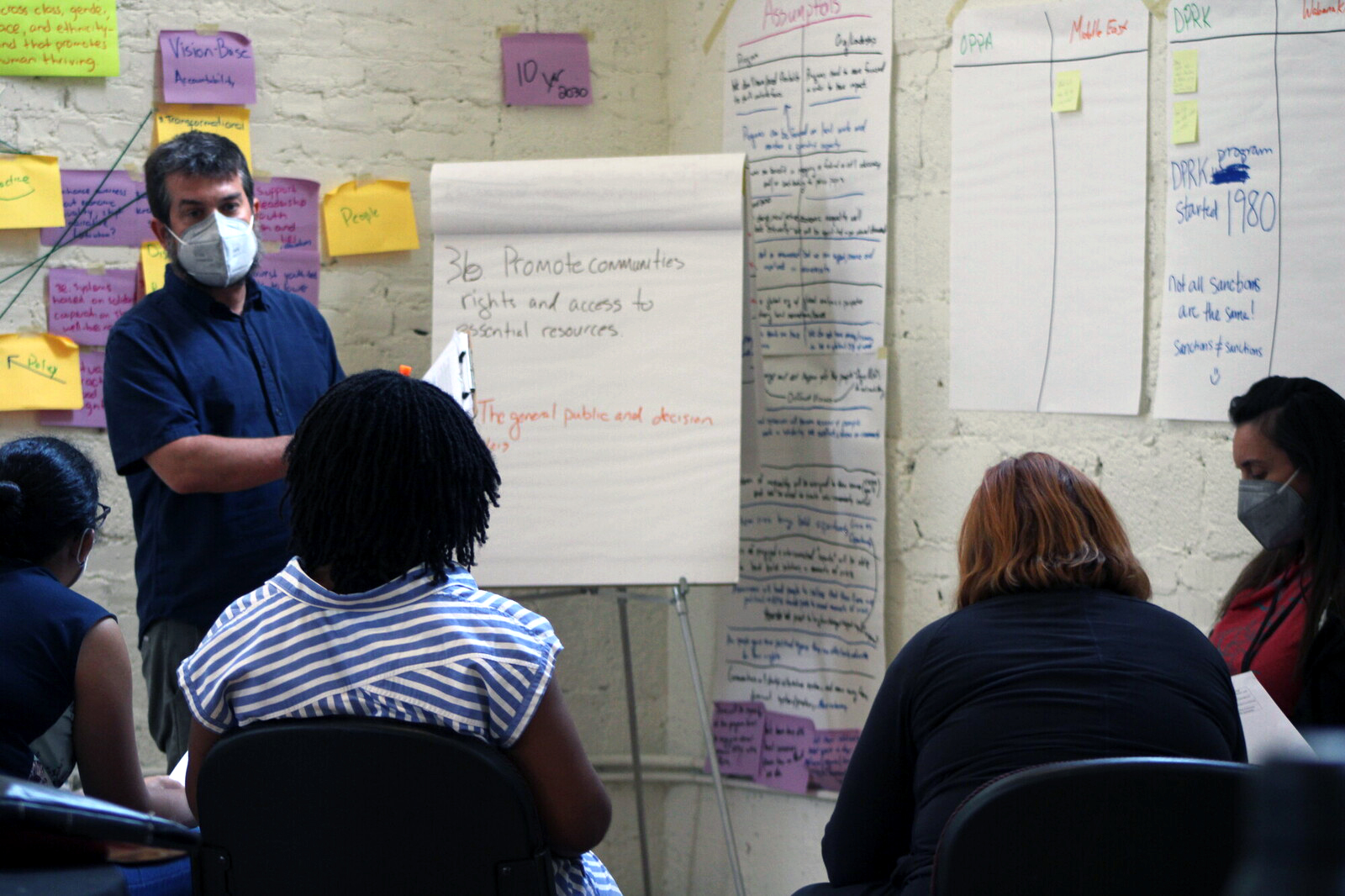 person pointing to a flip-board with sticky notes