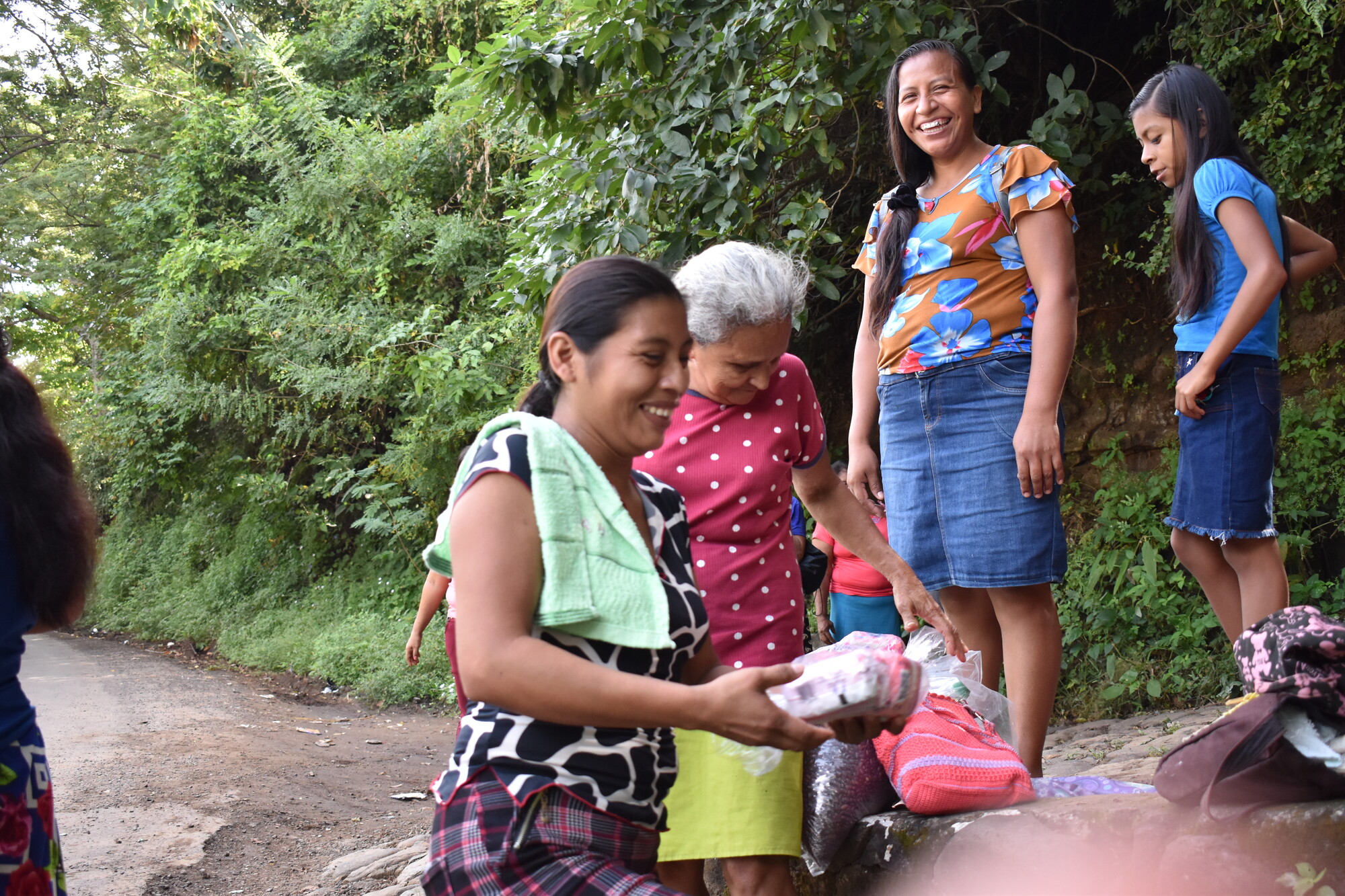 people smiling and sorting bags of food outside