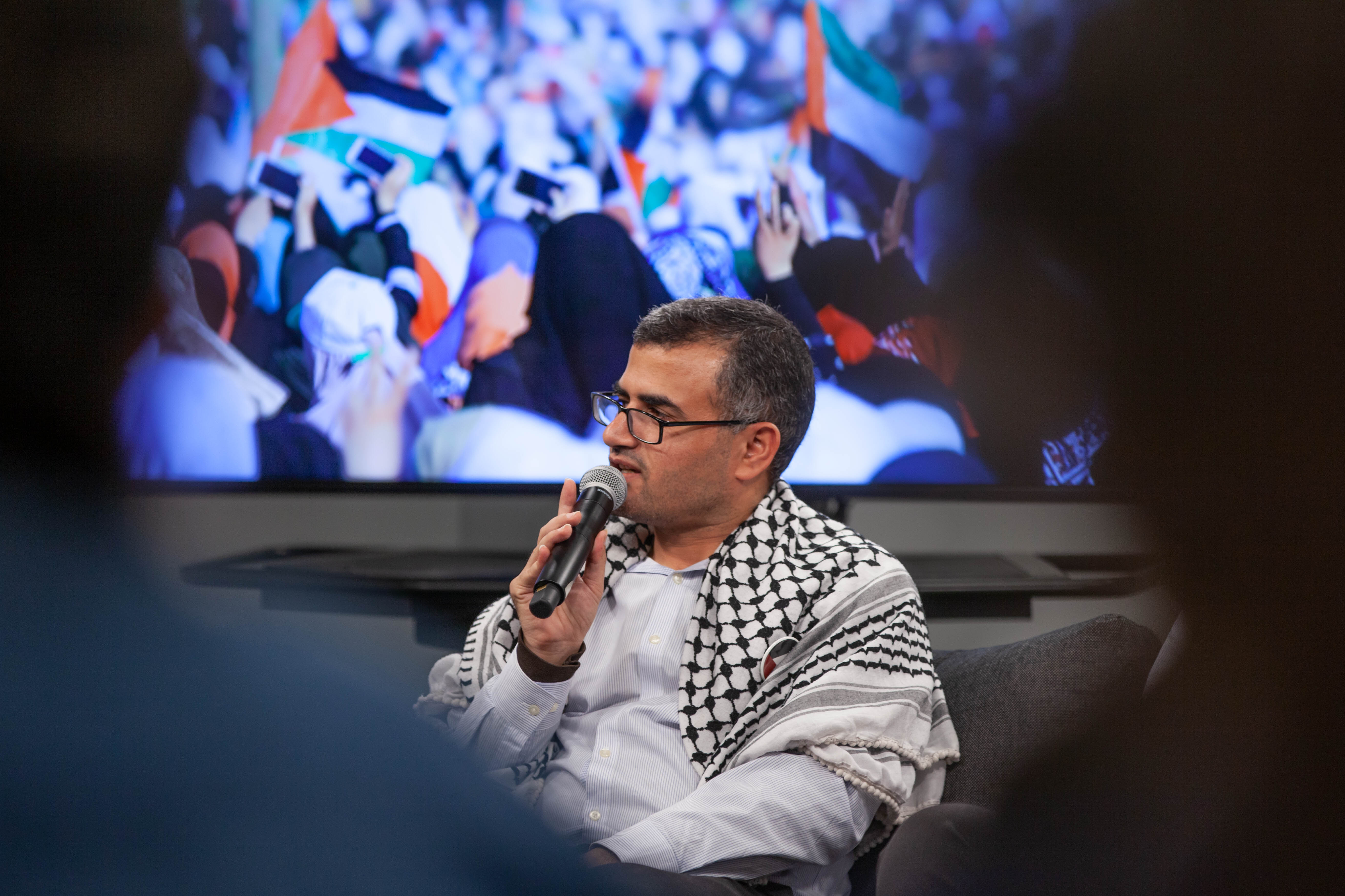 A prominent Palestinian organizer speaks to an audience during a speaking tour