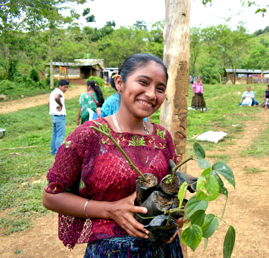 girl holding plants and smiling
