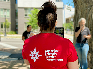 Person livestreaming a press conference wearing an AFSC t-shirt