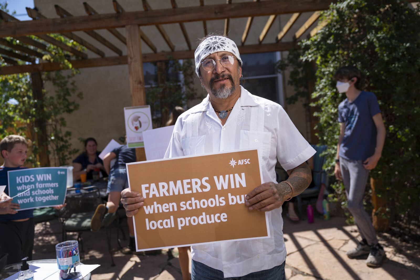 Cherry farmer from New Mexico holding sign that reads farmers win when schools by local produce.