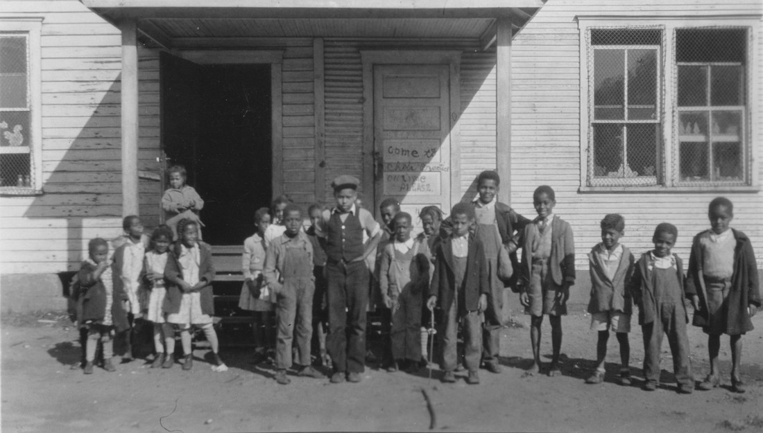 Children standing in front of a building