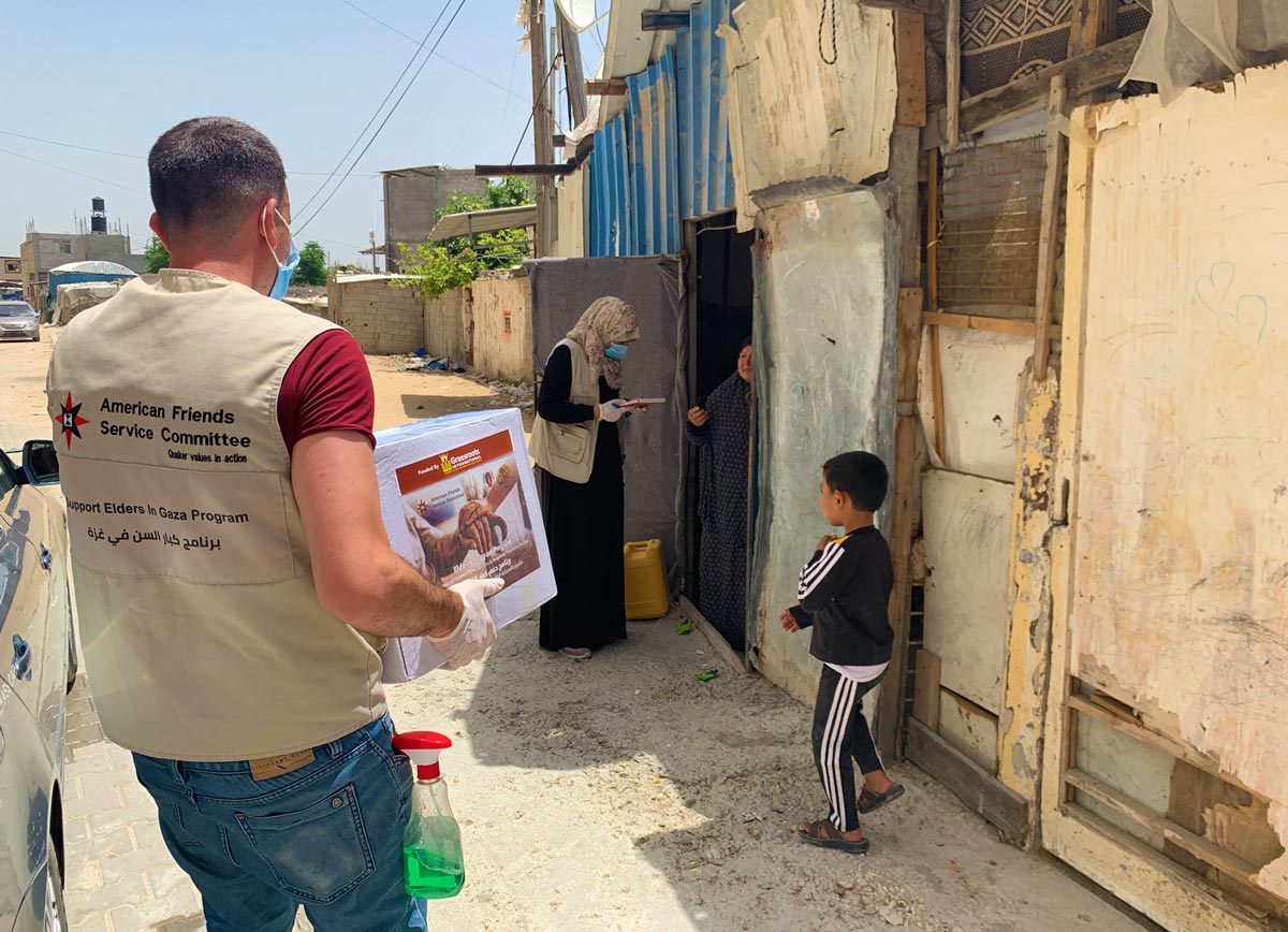 Two AFSC staff members deliver a box of COVID hygiene supplies to a home in Gaza