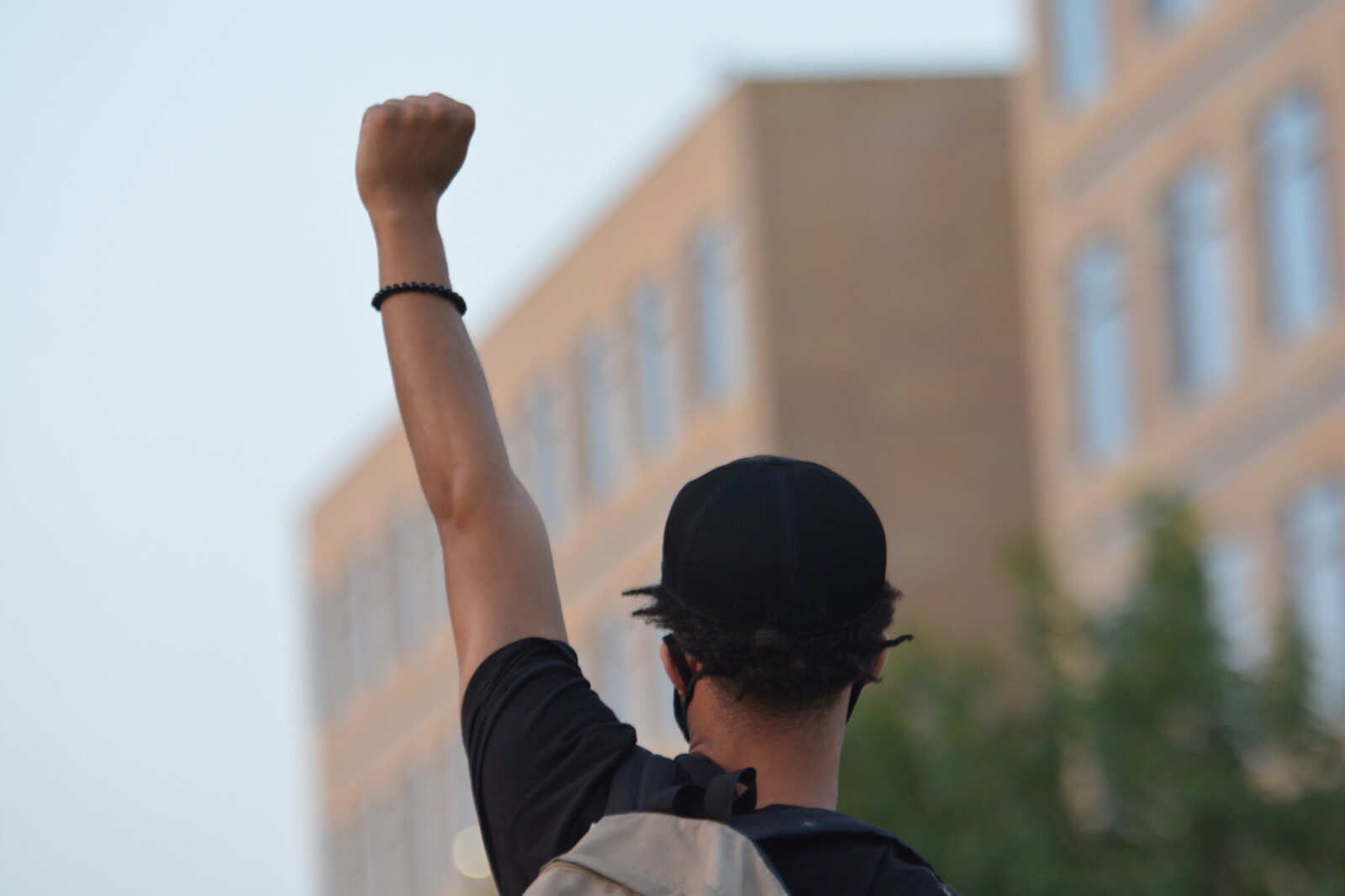 young man holding fist in the air outside detention center