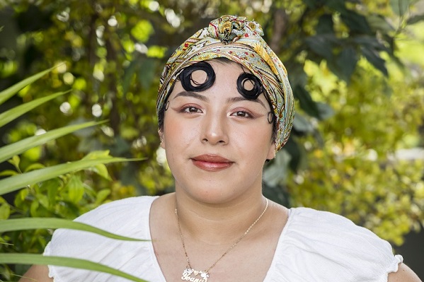 Photo of Yoana Morales wearing a headscarf and a white shirt