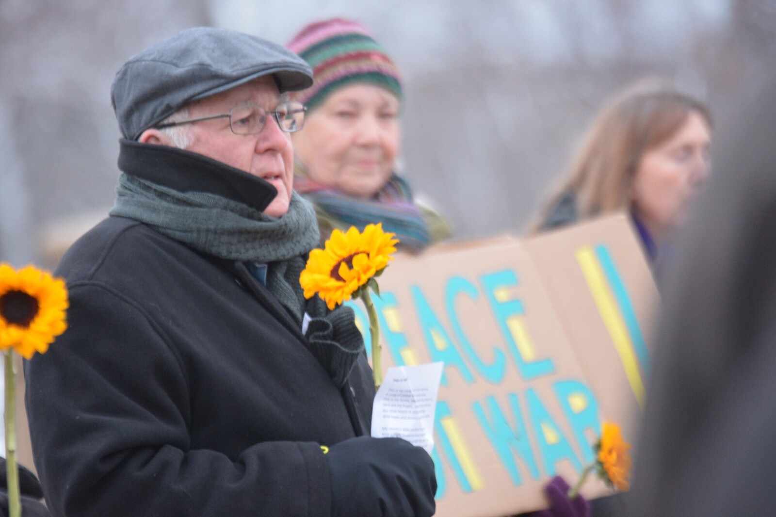 Man holding sunflower at prayer vigil for peace in Ukraine and beyond 