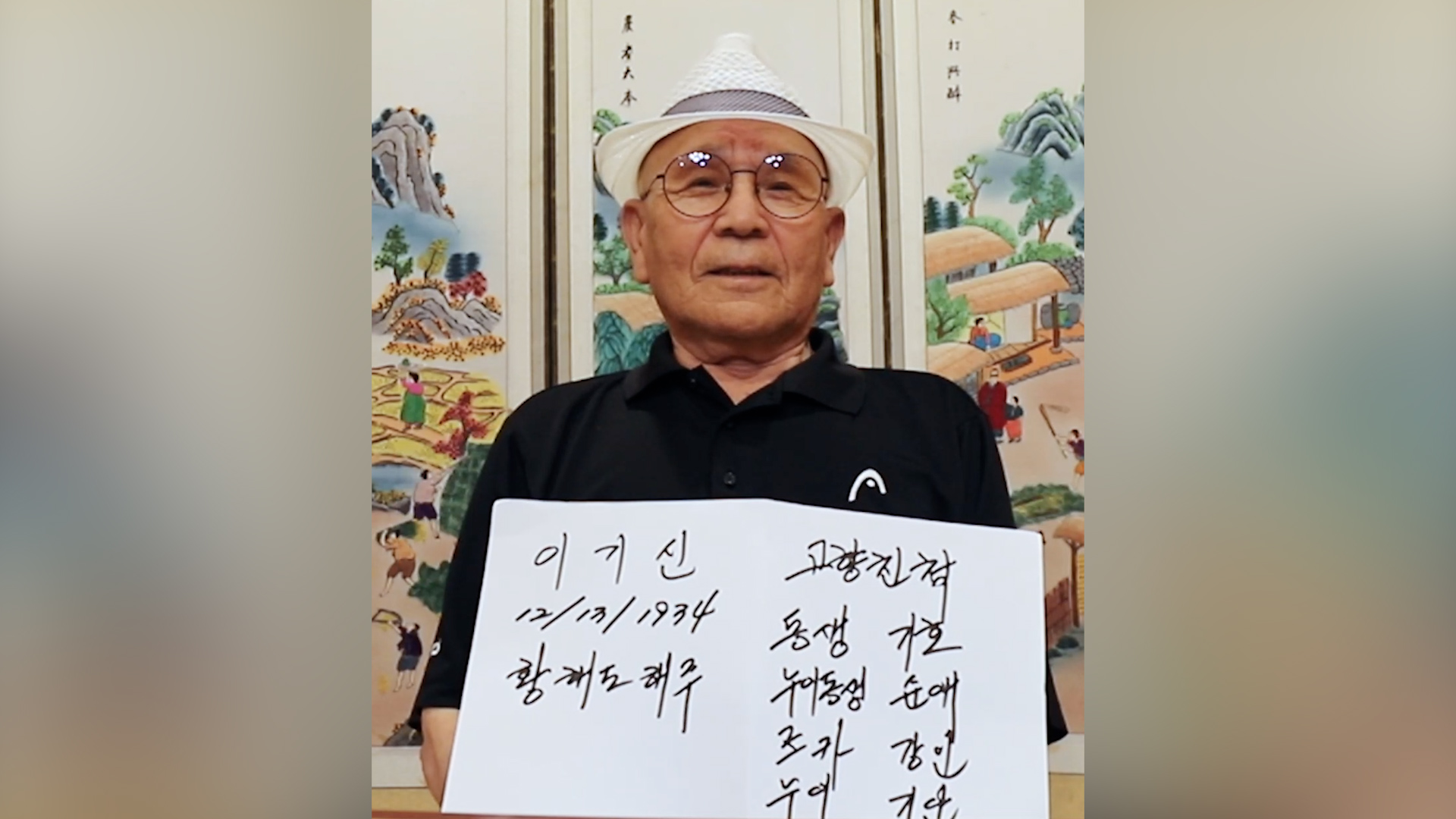 Man holding a handwritten sign looking into the camera
