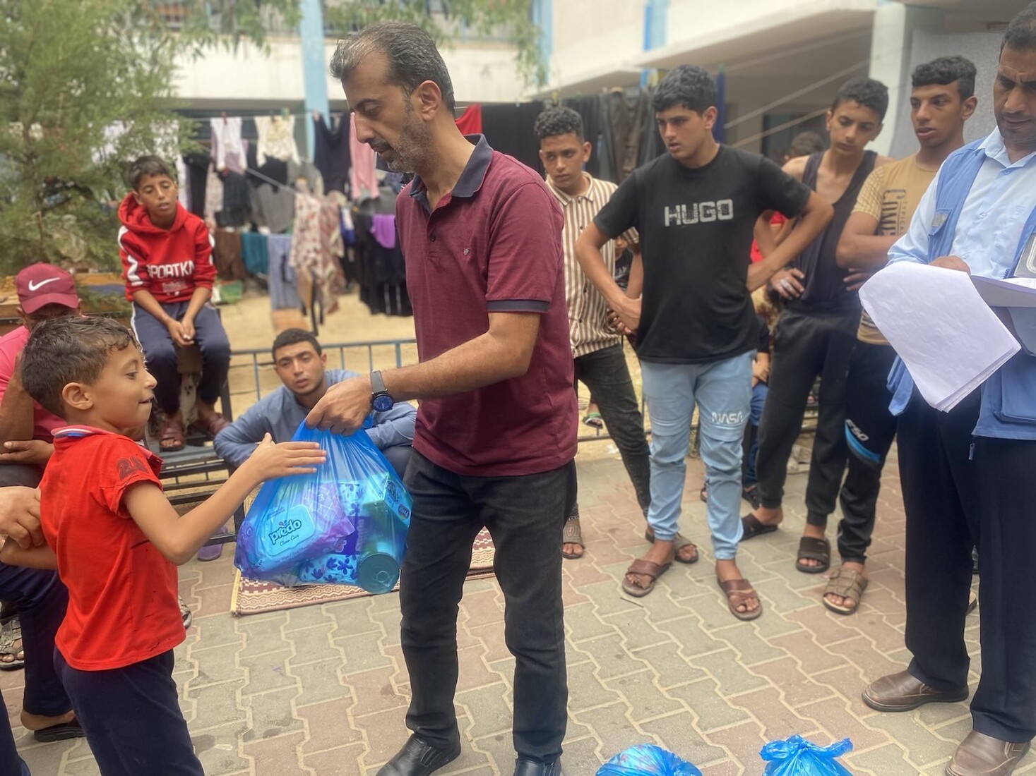 AFSC staff hand a bag of food to a child