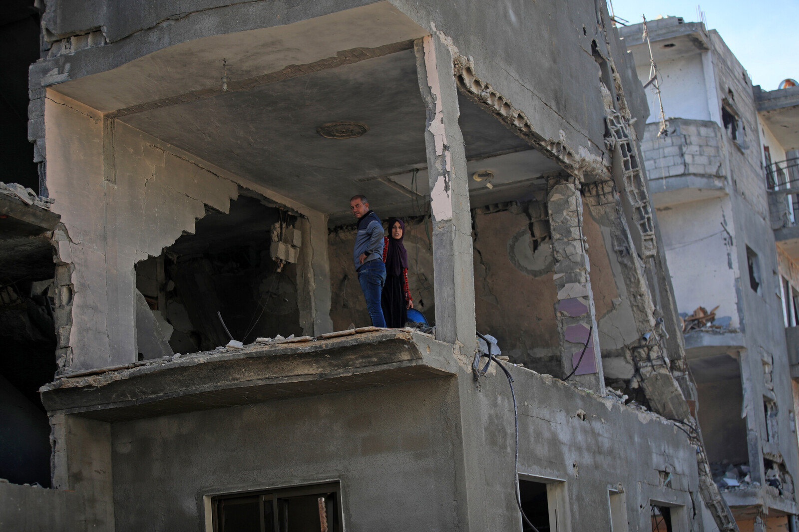Man and woman stand in a bombed out building