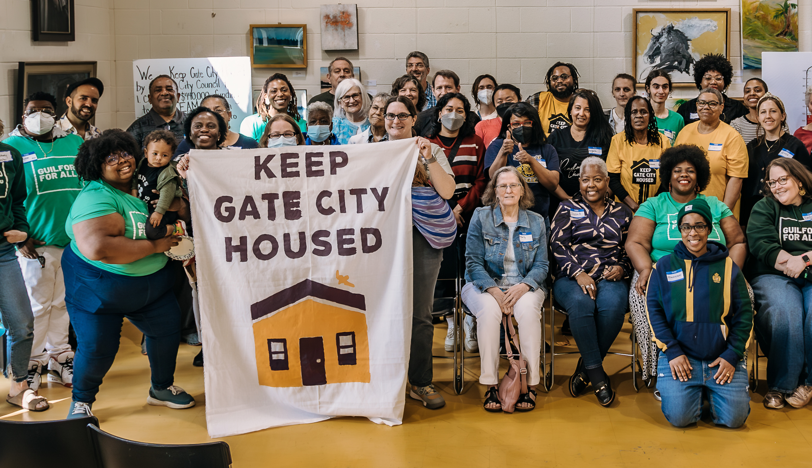 Image of group with 'Keep Gate City Housed' banner, cropped