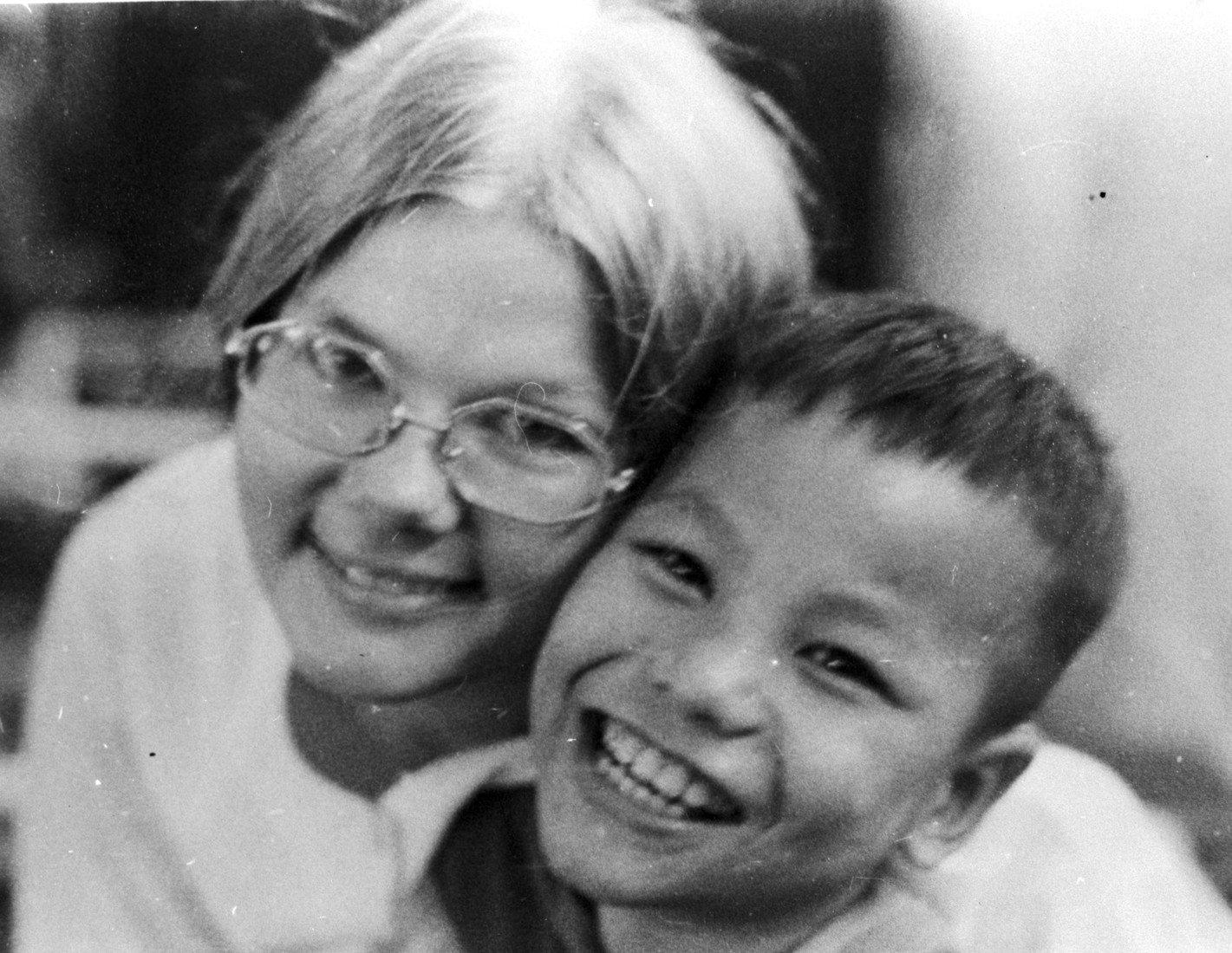 A woman and young boy smiling into the camera