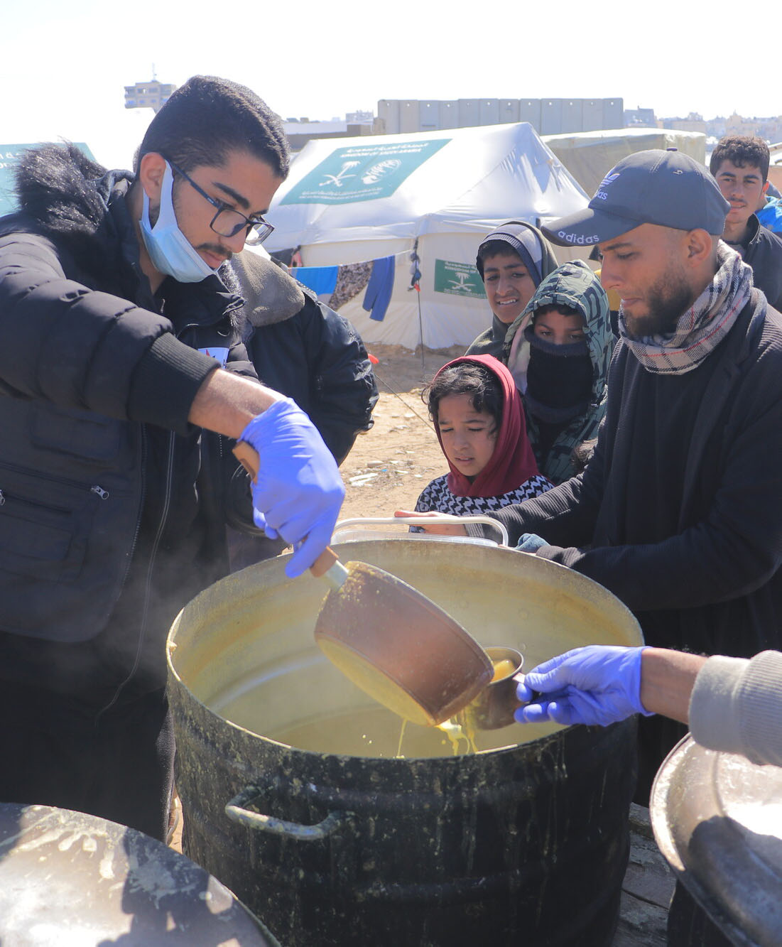 Volunteer serving soup to the displaced in Gaza