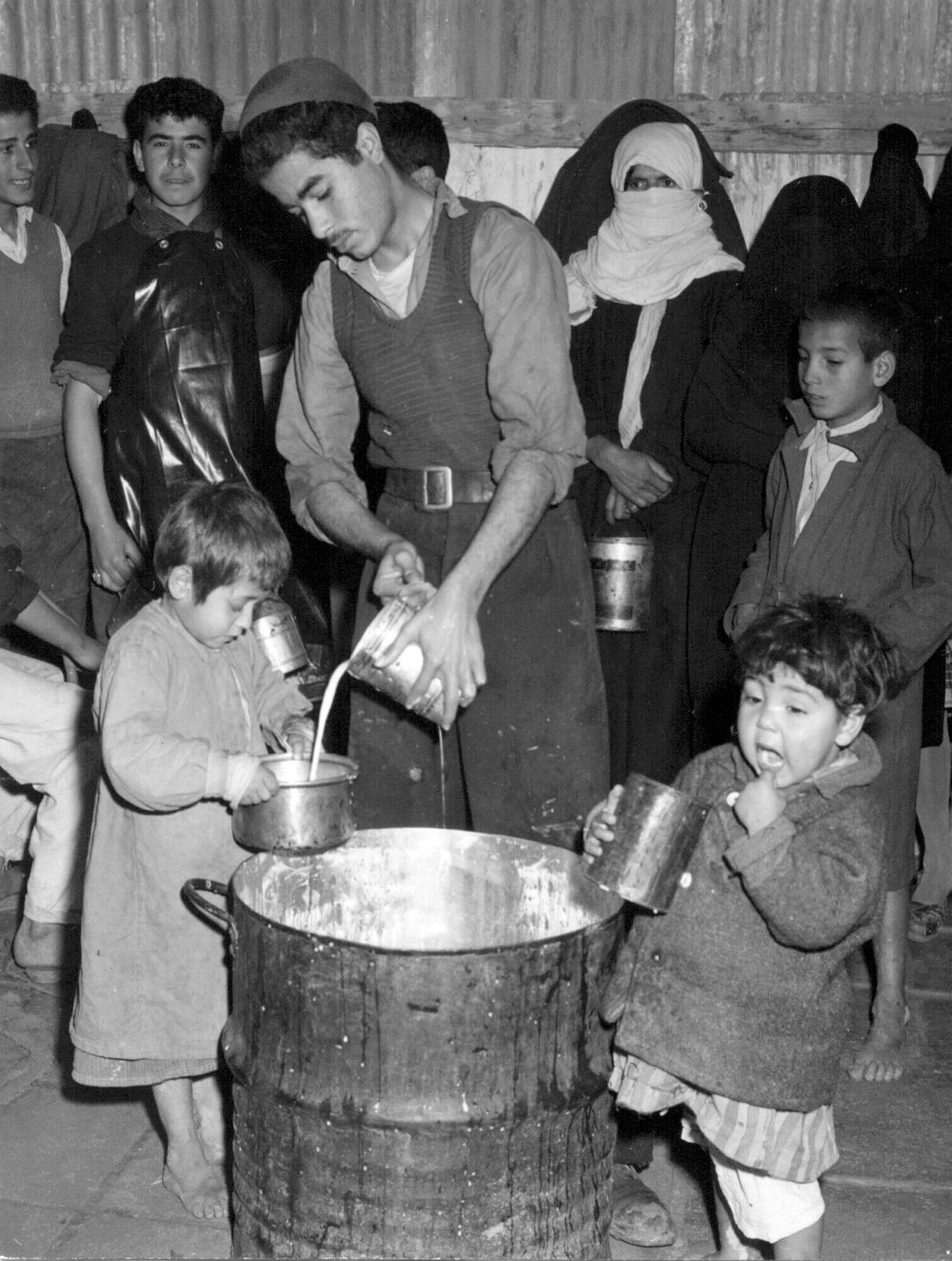 Aid worker in Gaza serving soup to young children
