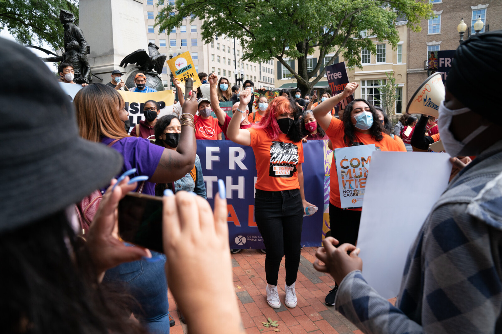 Image of young people rallying with posters that say 'Communities Not Cages'