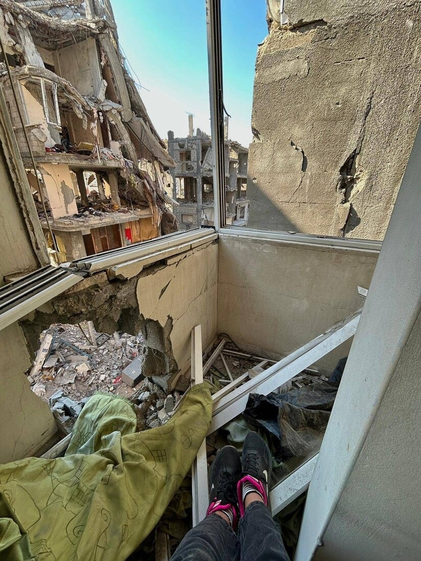 A view of the ruins of building from inside another damaged building