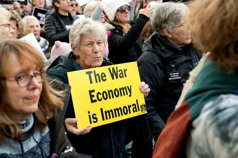 Protester in crowds holds sign 