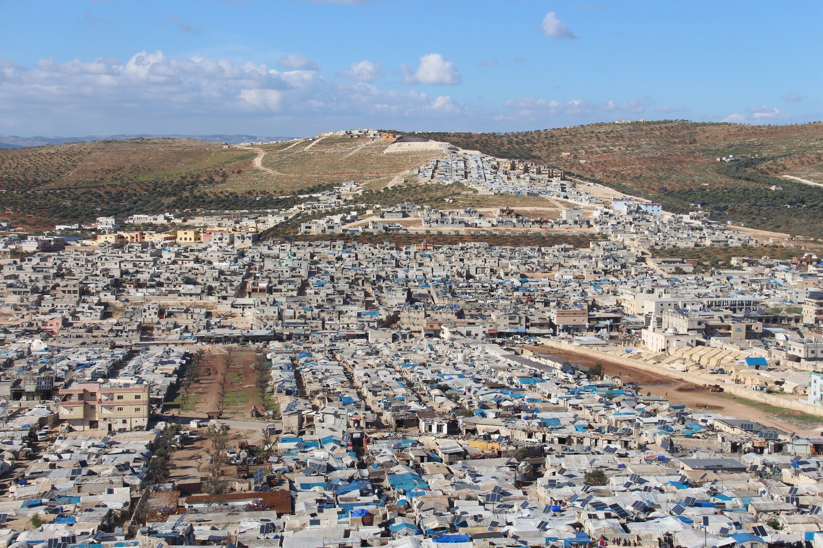 A hillside with many one story buildings and tents
