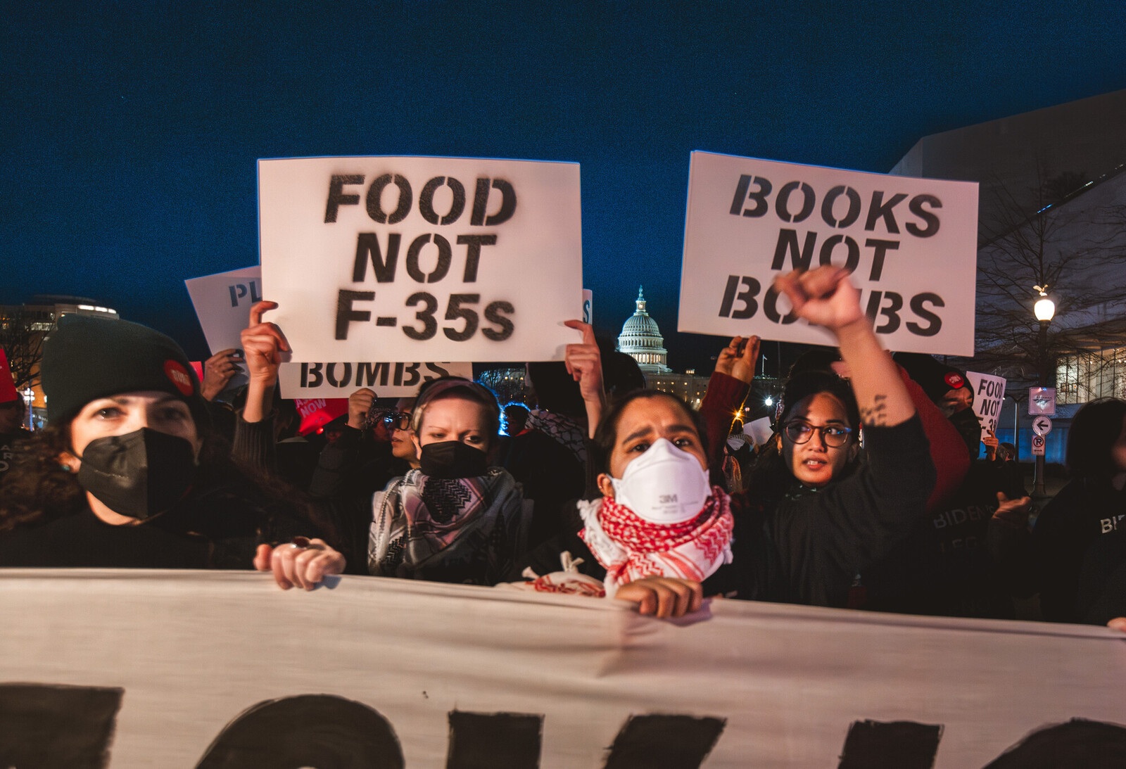 Protesters hold signs that say 