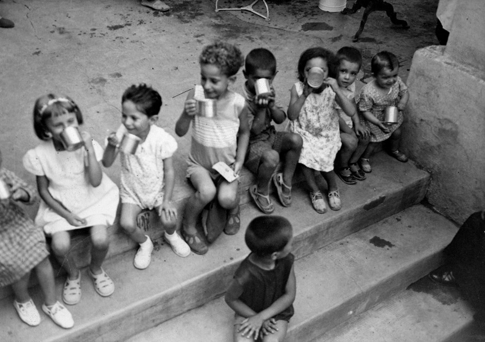 Black and white photo of children sitting on a step