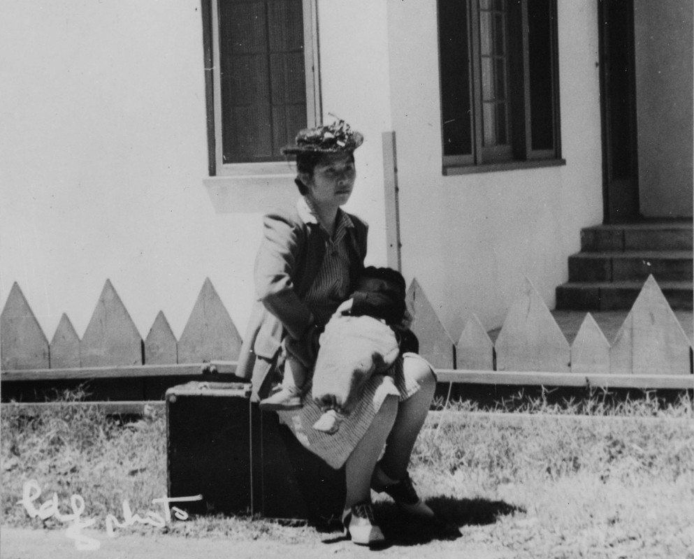 Woman sitting outside on a suitcase