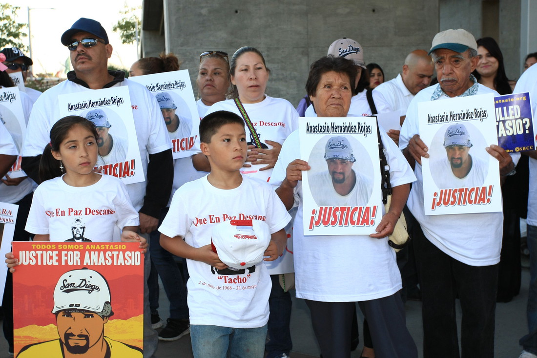 Group of people holding signs at a vigil