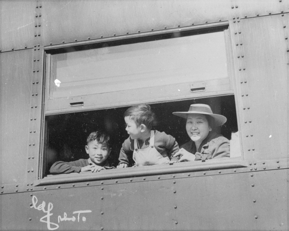 Woman and two children looking out from a train window