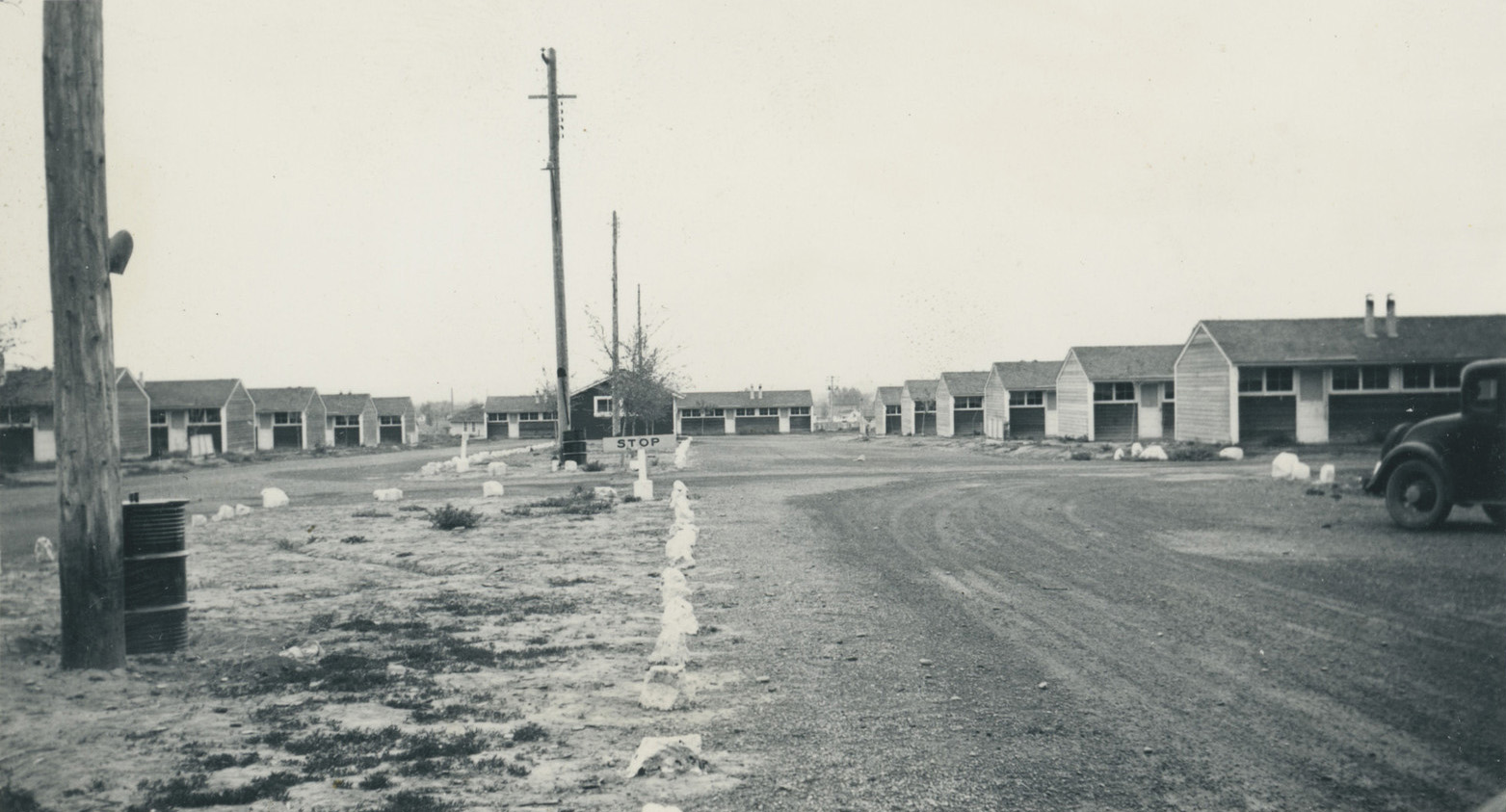 Black and white photo of a street with dwellings on either side