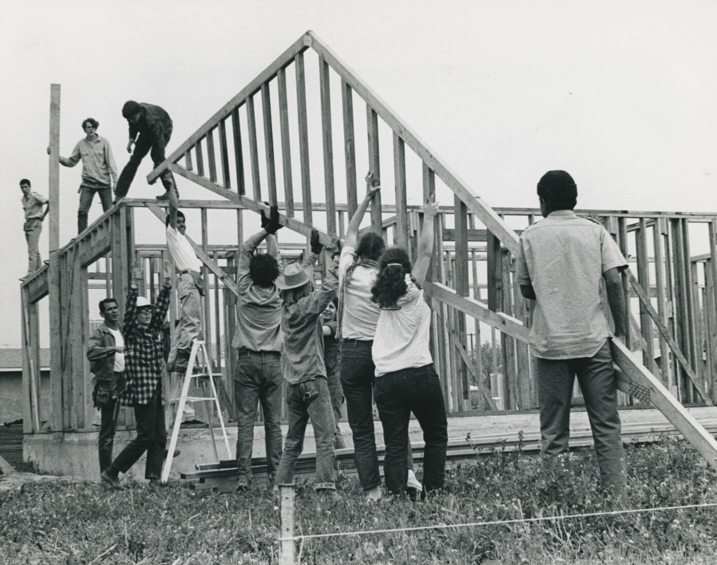 Group of people assembling a house frame
