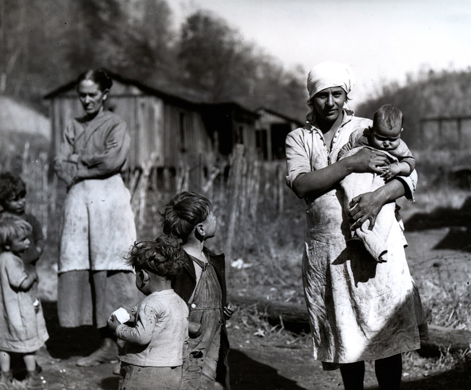 Woman holding a young child outside on a farm
