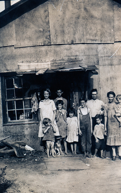 Large family standing outside their house.