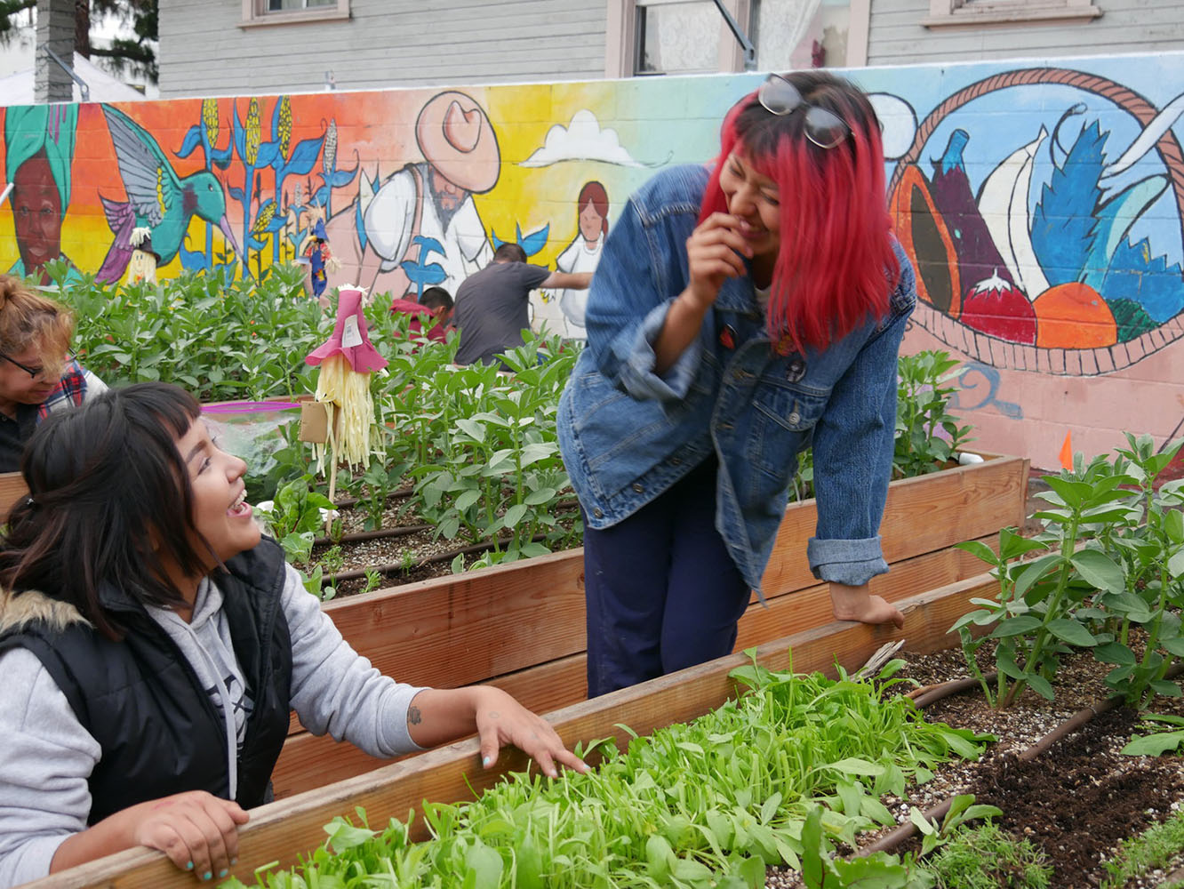 Two women talking in front of a garden bed
