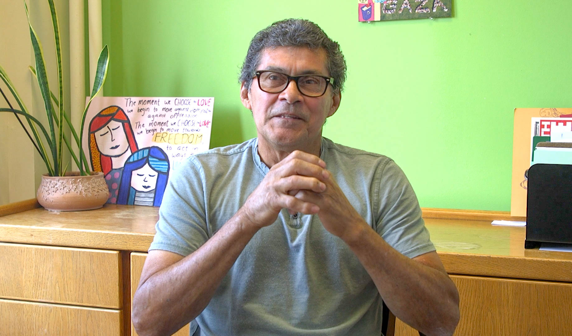 Man sitting in an office, giving an interview