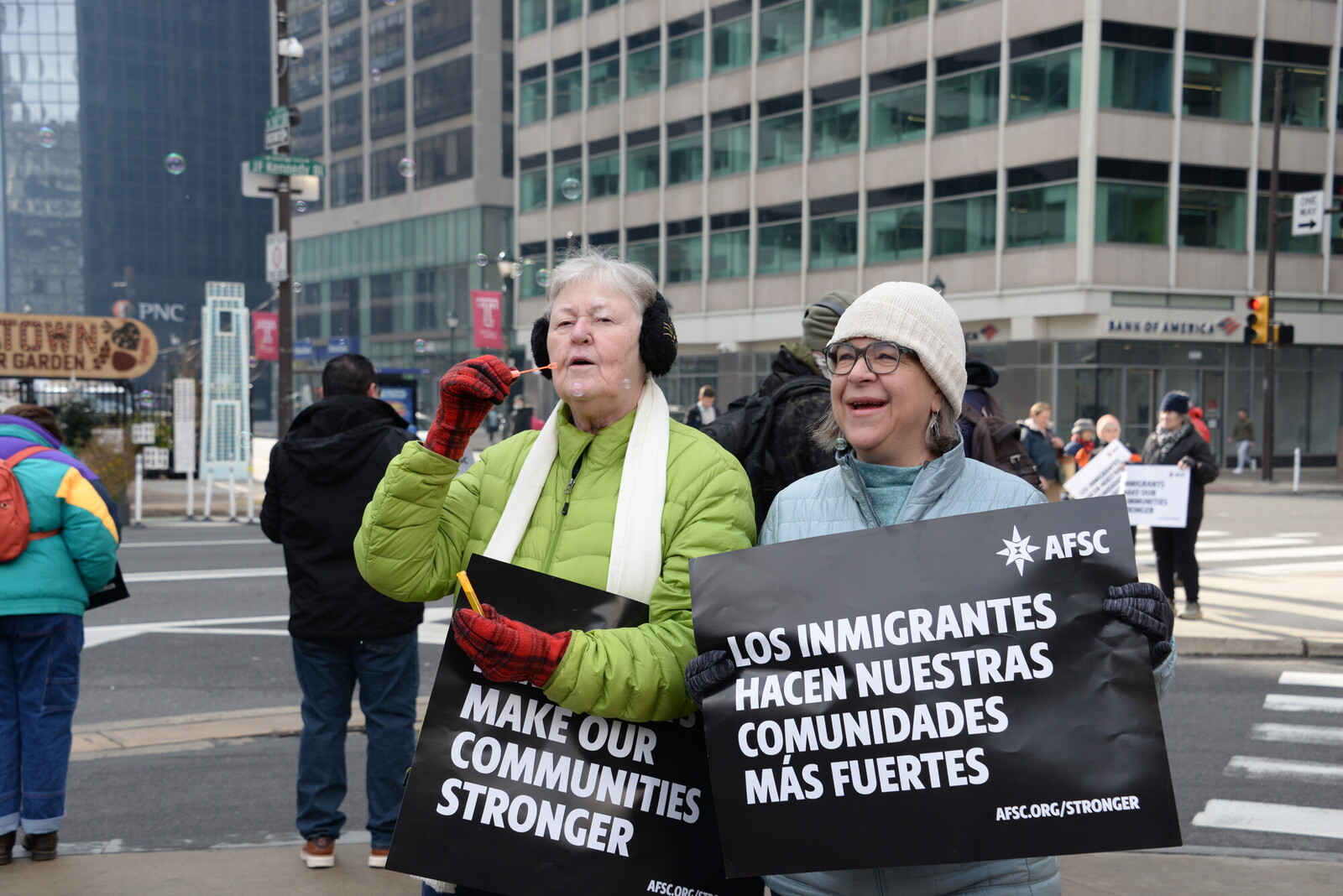 Two women hold signs saying 