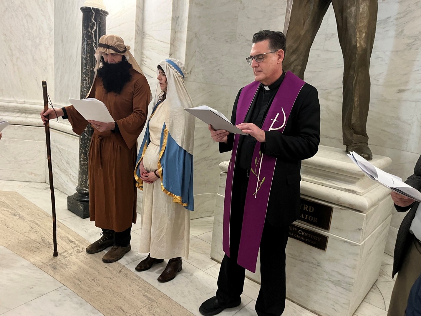  Rev. Msgr. Paul Hudock performing Las Posadas service in upper rotunda at WV State Capitol. 