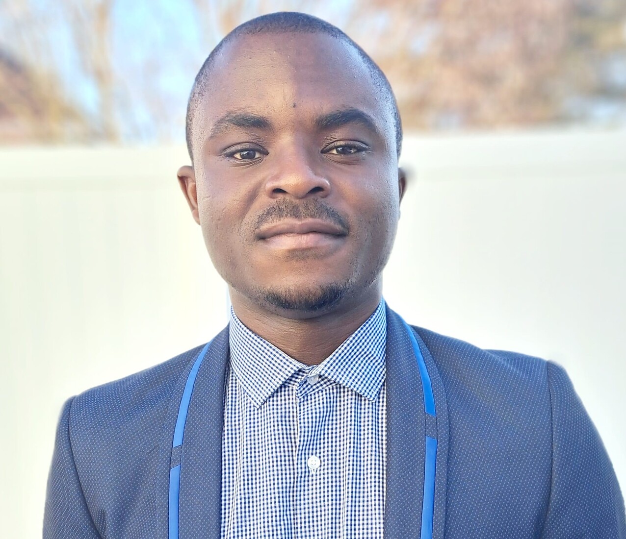 Portrait of a man with a collared shirt and blue jacket