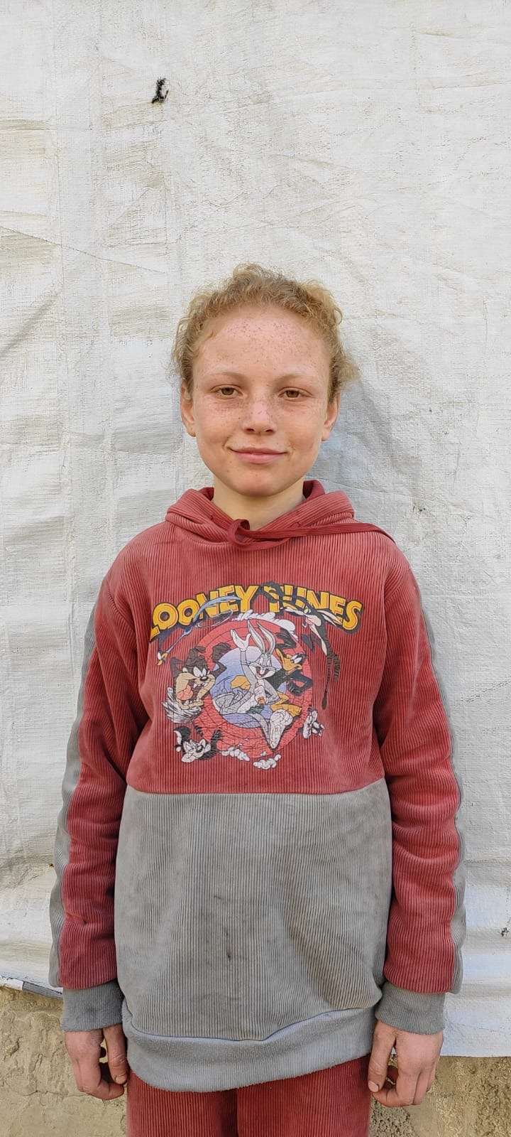 Girl in a red hoodie stands 