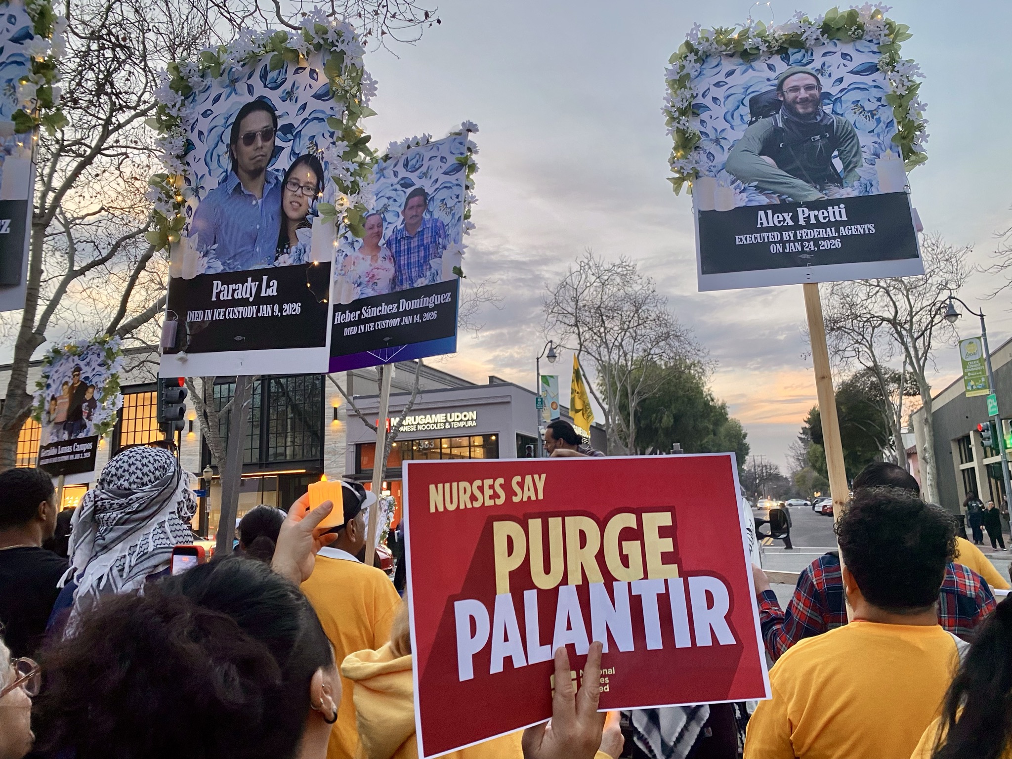 Protest with signs of those killed by ICE and signs reading Purge Palantir