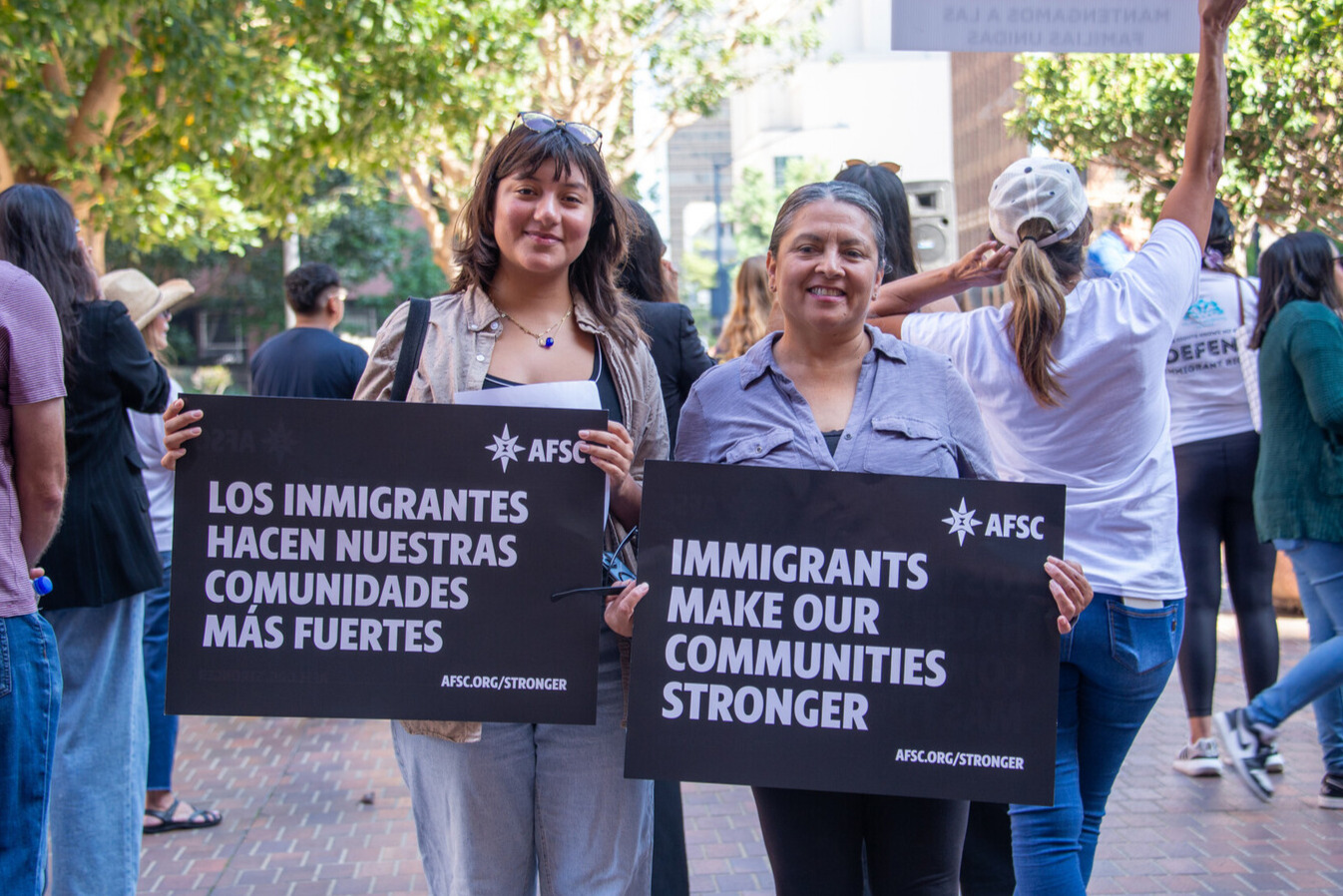 Demonstrators hold signs supporting immigrants.