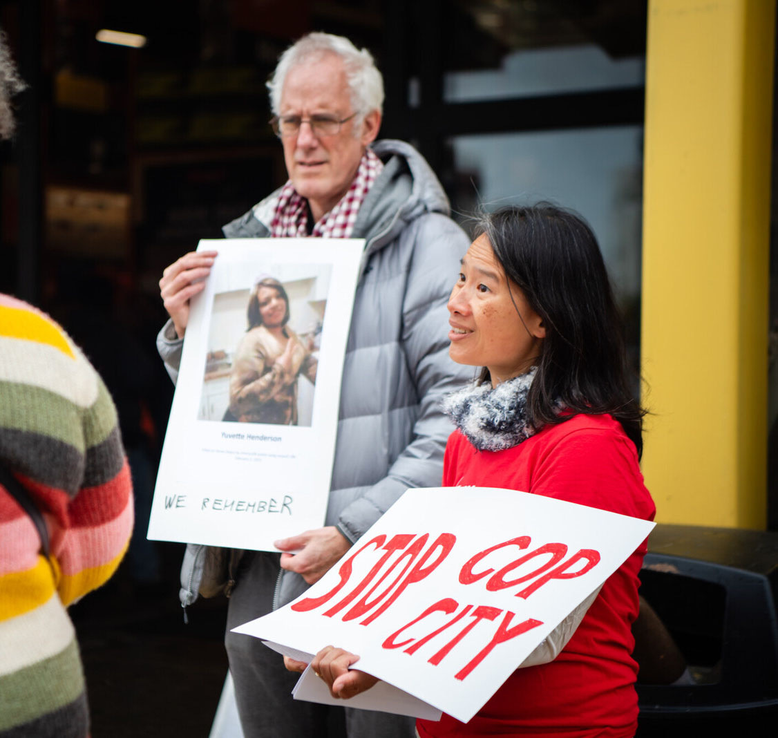 two people protesting and holding a poster that says stop cop city