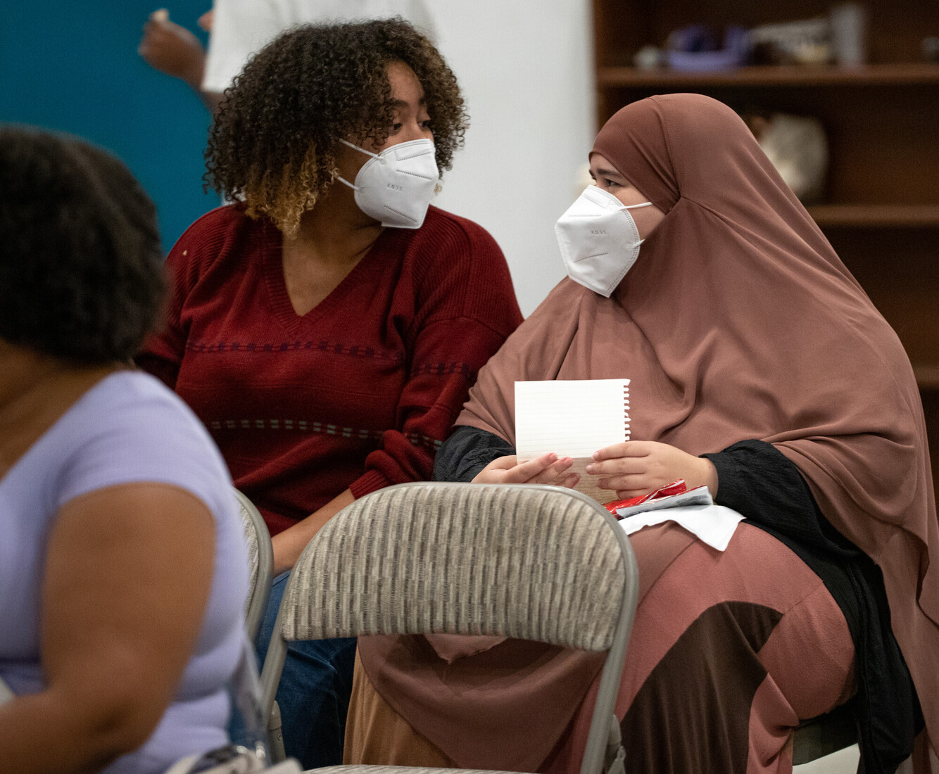two people wearing masks smiling at each other