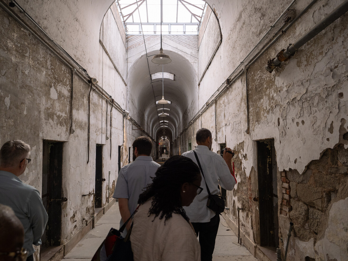 people walking through an old prison
