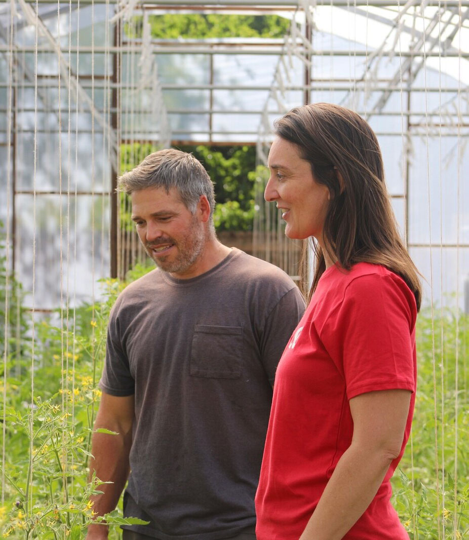 photo of people in a greenhouse looking at plants