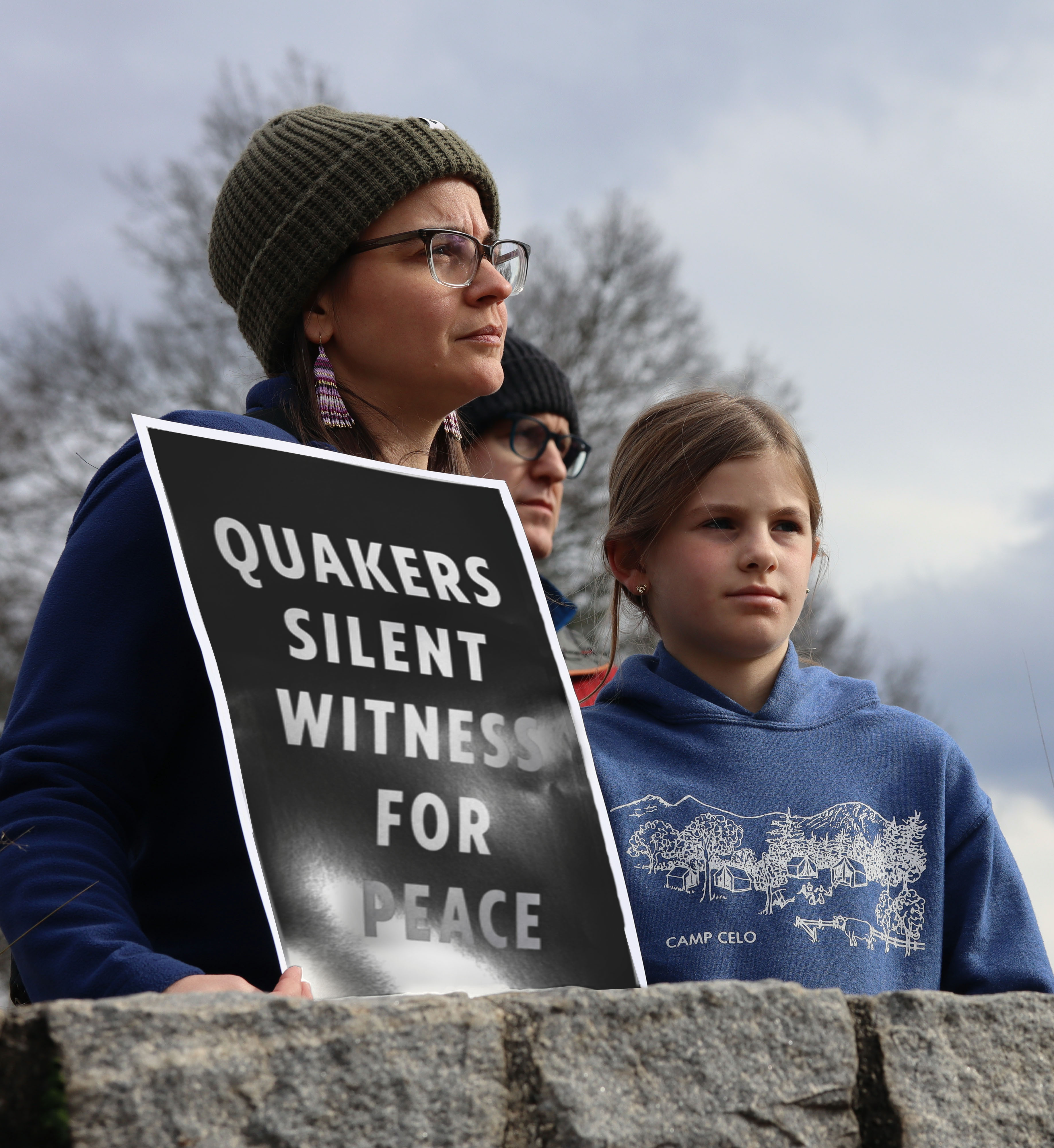 people holding sign that says quakers silent witness for peace