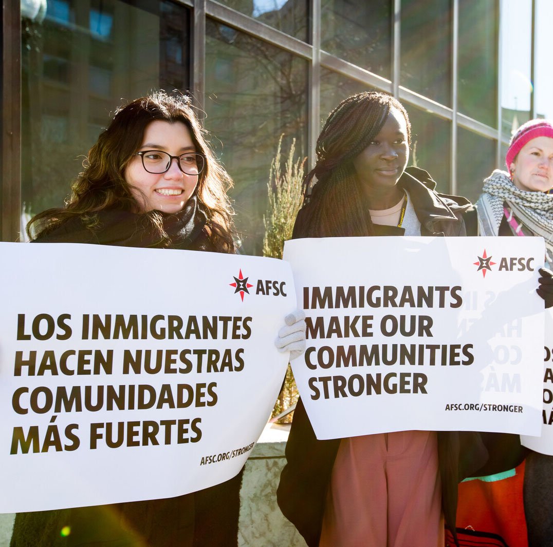 people holding signs that say immigrants make our communities stronger